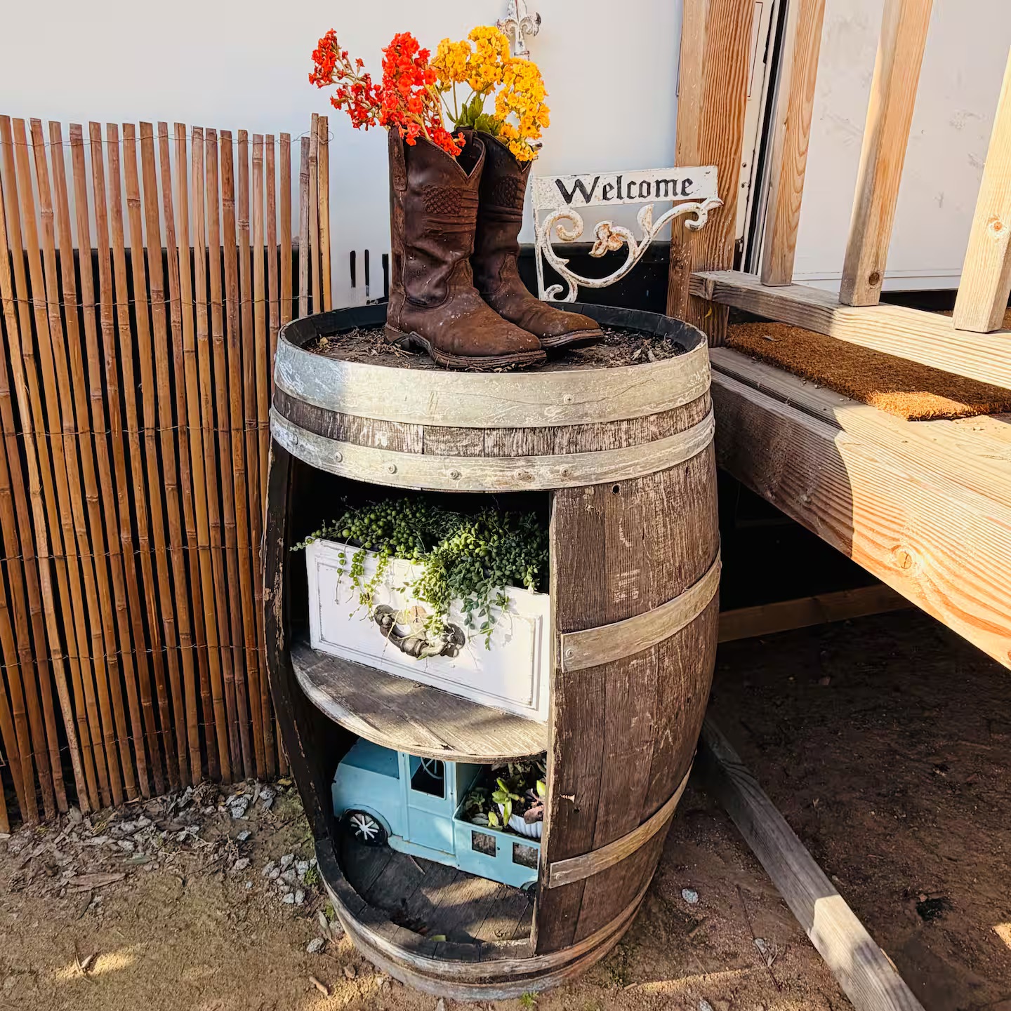 Cowboy boots with flowers, welcome sign, and rustic porch details at The Roost
