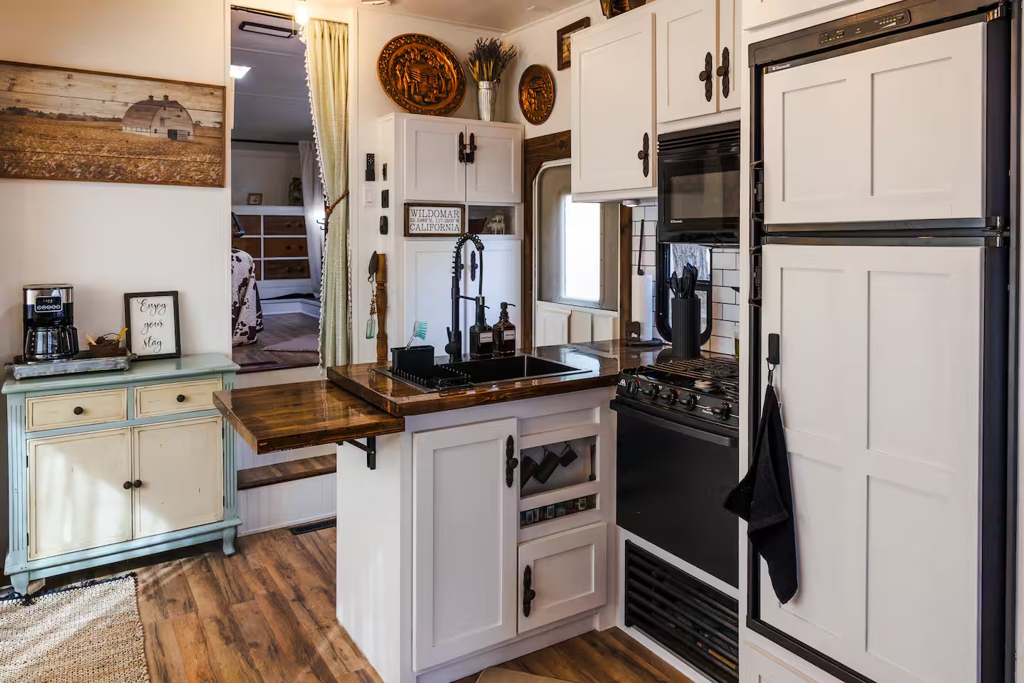 The Roost kitchenette with sink, stove, refrigerator, and warm wood counter